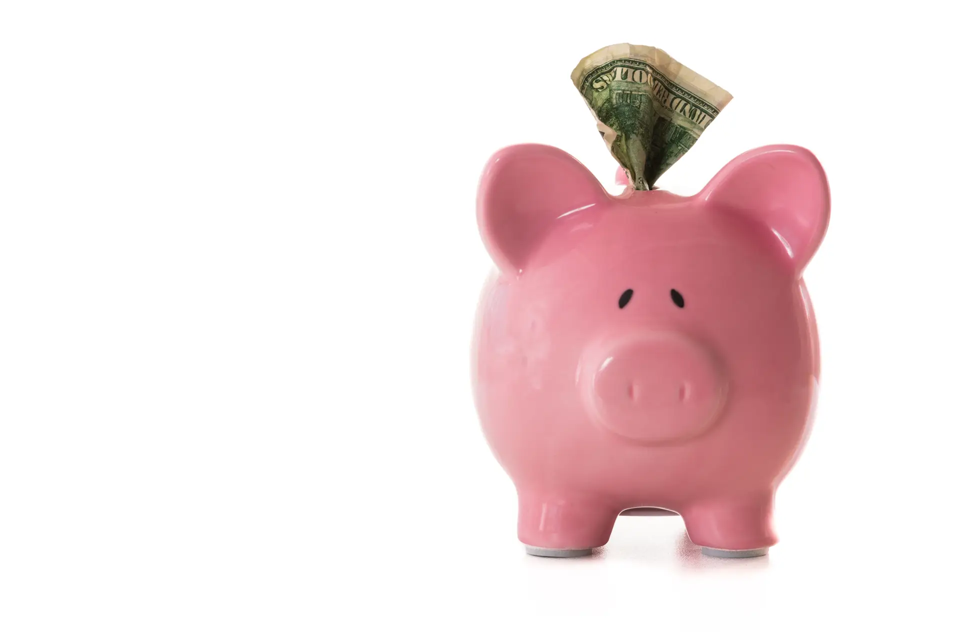 Dollar note sticking out of piggy bank on white background