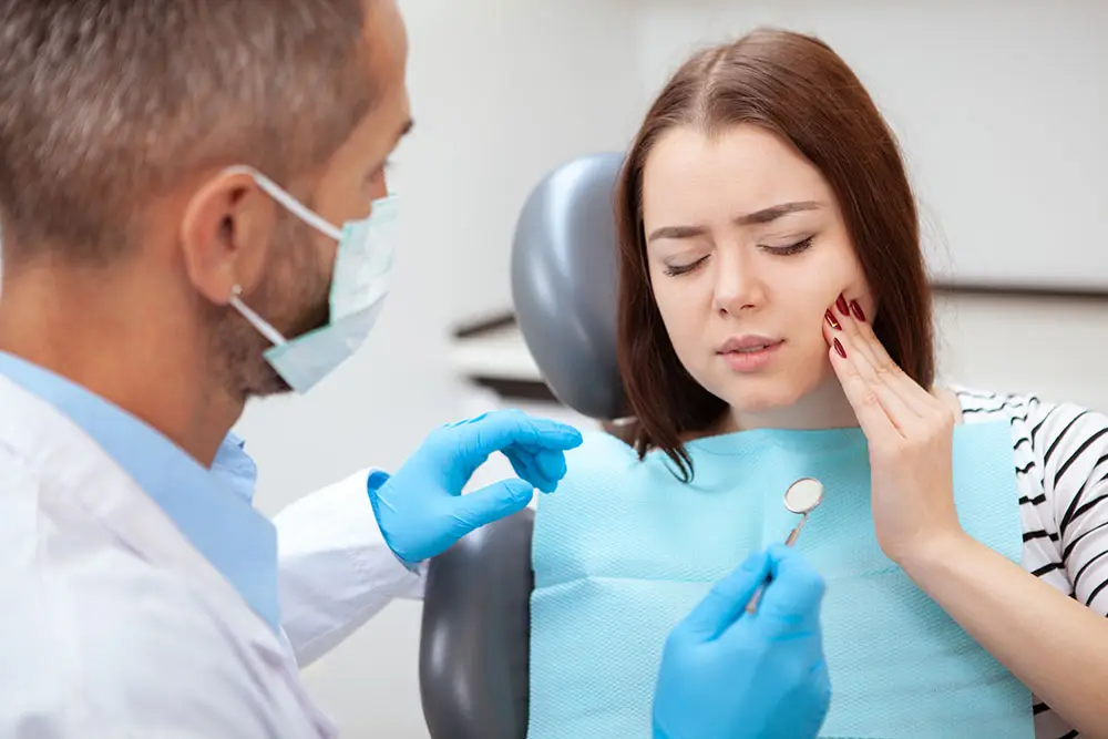 Girl holding her mouth from dental pain